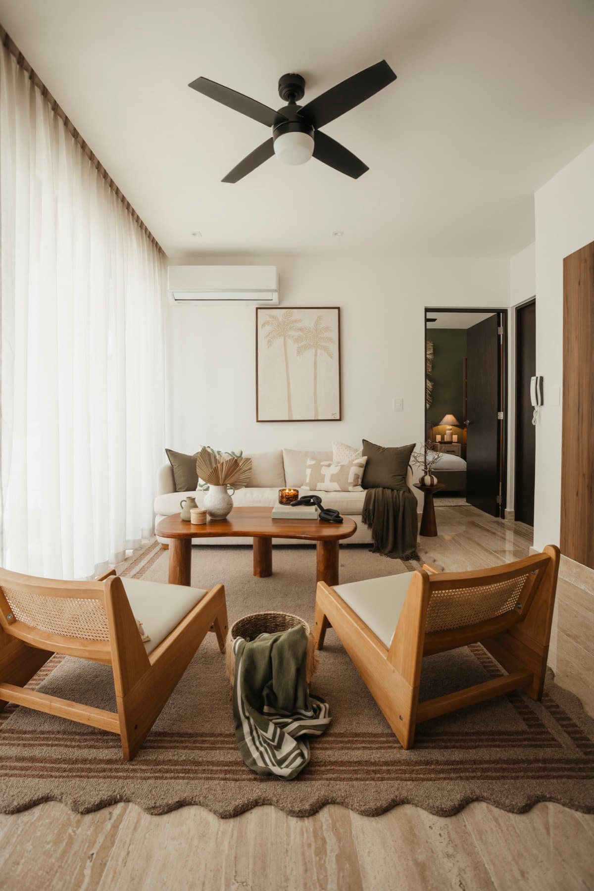 Ceiba at 25 living area with neutral sofa, wood accents, and natural light