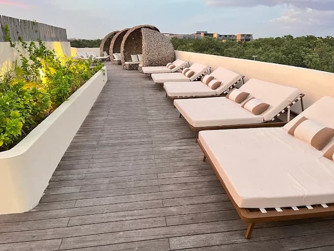 Rooftop terrace lounge with daybeds and jungle views at Artia Condos